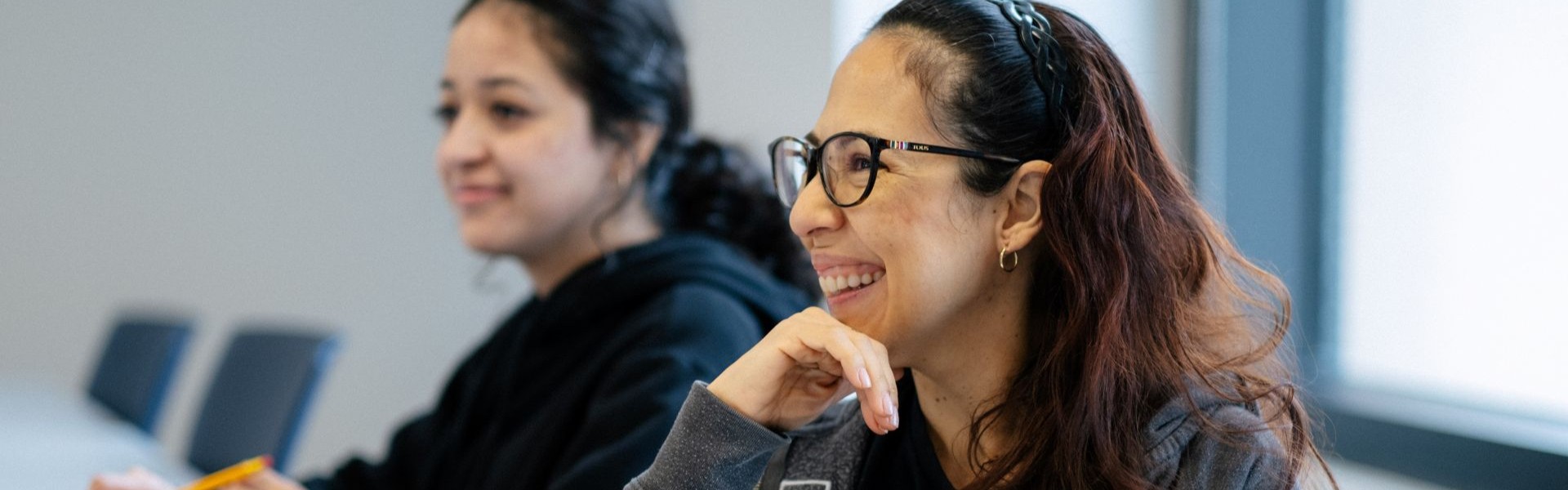 Estudiante adulta sonriendo durante la sesión de clase.